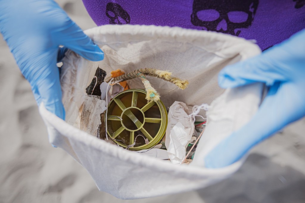 beesure-ocean-blue-project-cleanup-volunteer-trash-in-can-plastics